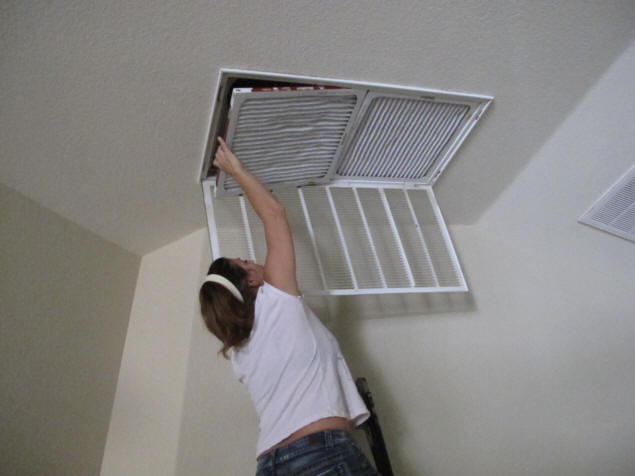 Jenny installs the replacement HVAC filters.