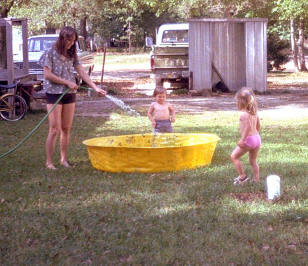 Mary, Johnny and Jenny begin filling the pool.