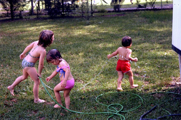 Dottie, Jenny, and Johnny enjoy the garden hose.