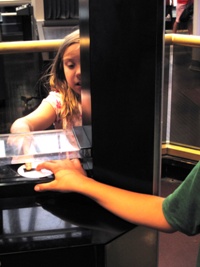 Cailey and Zach touch a moon rock.