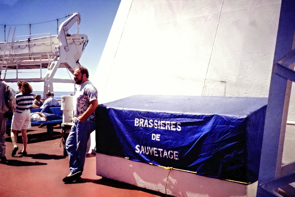Paul leaning against a box of "savage brassieres",
